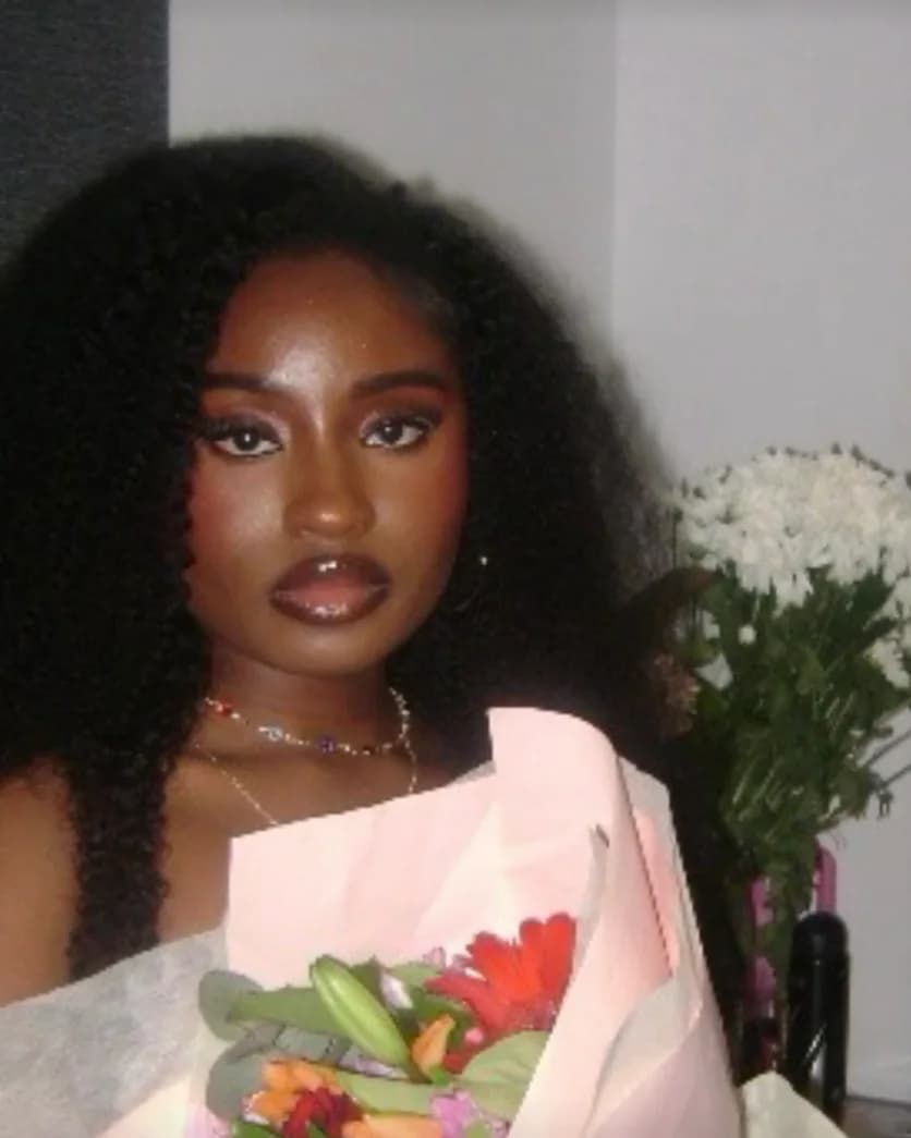 Fikayo, founder of Glowa, holding a bouquet of flowers