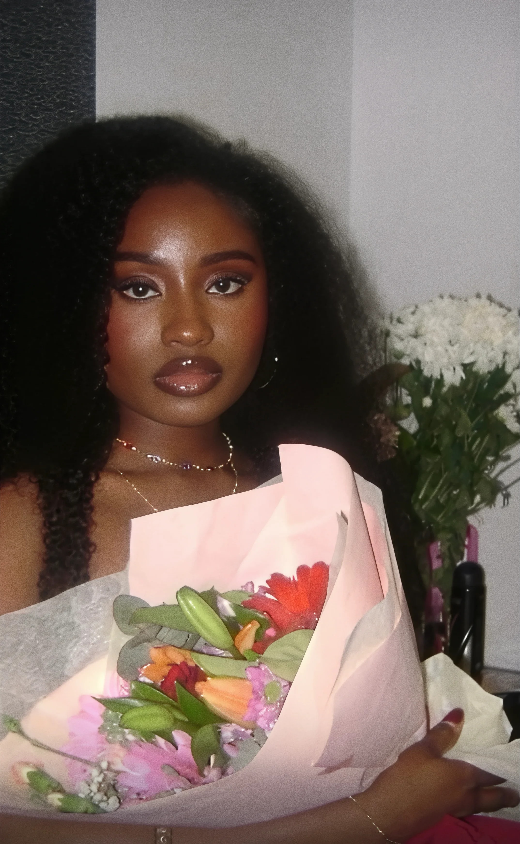 Fikayo, founder of Glowa, holding a bouquet of flowers